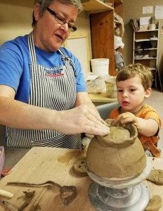 Maggie Anderson helps a youngster handbuild a bowl for Empty Bowls. (File photo)