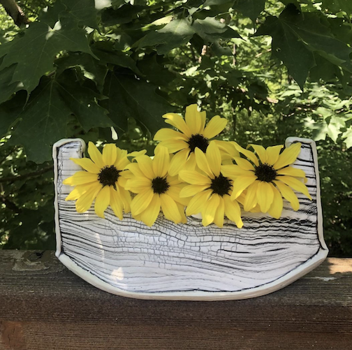 Flowers traveling in a boat, vase by Maggie Anderson. She will be exhibiting her work at the Grand Marais Arts Festival.
