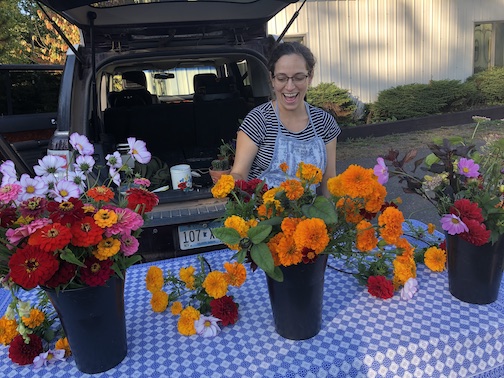 Monica Anderson arranges a few of the fall flowers she is offering at the Local Food Market. The market also features fresh vegetables, eggs, wood-fired artisan breads, locally harvested wild rice, fresh eggs and locally produced salves and balms. 