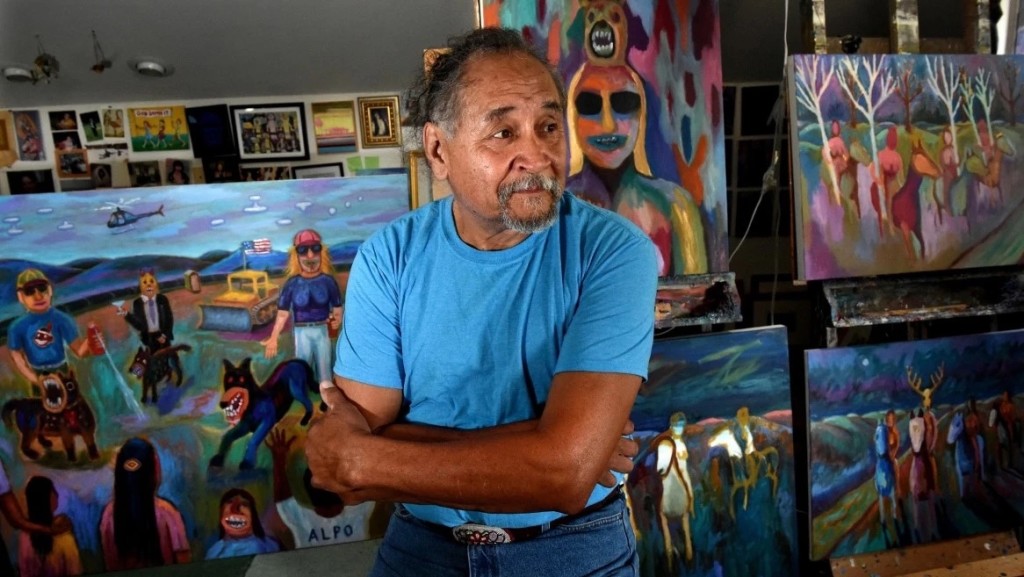 Jim Denomie in his studio in Shafer, Minn., on Wednesday, Aug. 28, 2019. The painting on the left is from his Standing Rock series. (Jean Pieri / Pioneer Press.