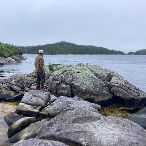 Dave Freeman stands on a Precambrian shield rock formation at t Cinq Cert Bay in Newfoundland. Photo  by Amy Voytilla.