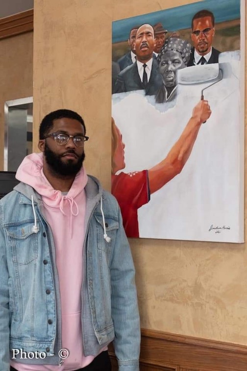 Artist Jonathan Harris and his painting titled Critical Race Theory.