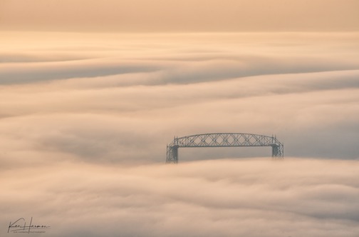 Lift Bridge emerges from wispy waves of fog on Lake Superior by Ken Harmon.