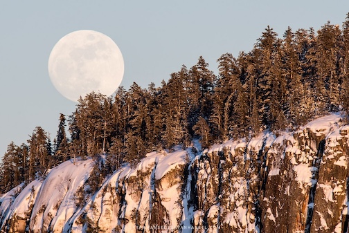 The full moon rises over cliffs in the Boundary Waters by Bryan Hansel.