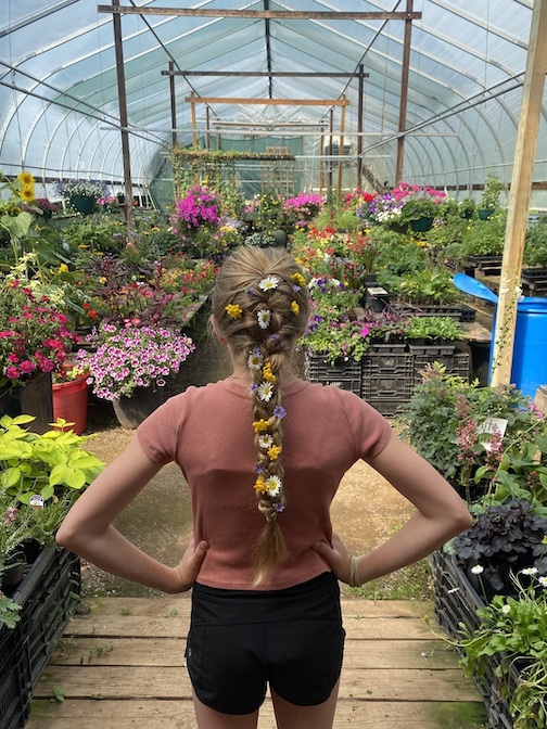 A flower girl pops into Maxwell's Woodland Nursery. The greenhouse just outside Finland is still open.